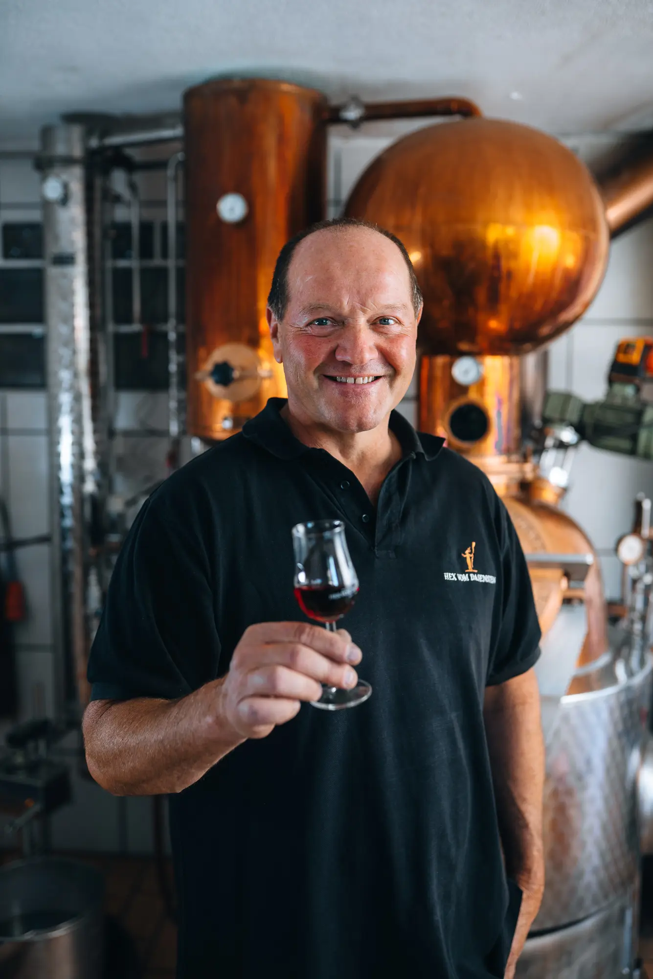Georg Baßler in der Brennerei mit einem Glas Edelbrand – Ferienwohnung und Hof in Kappelrodeck