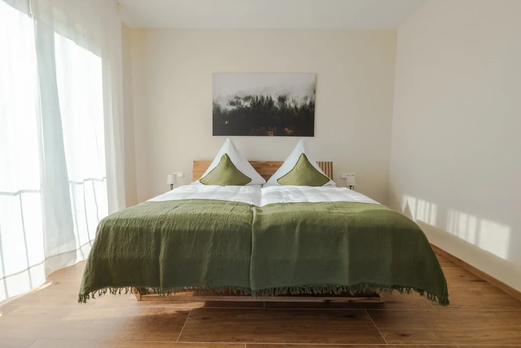 ferienwohnung-bassler_kappelrodeck-2000px-19 Schlafzimmer der Ferienwohnung Weinberg mit Doppelbett und Blick auf den Balkon