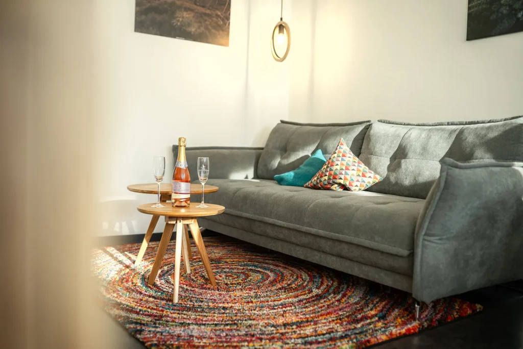 ferienwohnung-kappelrodeck-bassler-2000px-65 Gemütliches Wohnzimmer der Ferienwohnung Schlossblick in Kappelrodeck mit Sofa, Couchtisch und Sekt zur Begrüßung